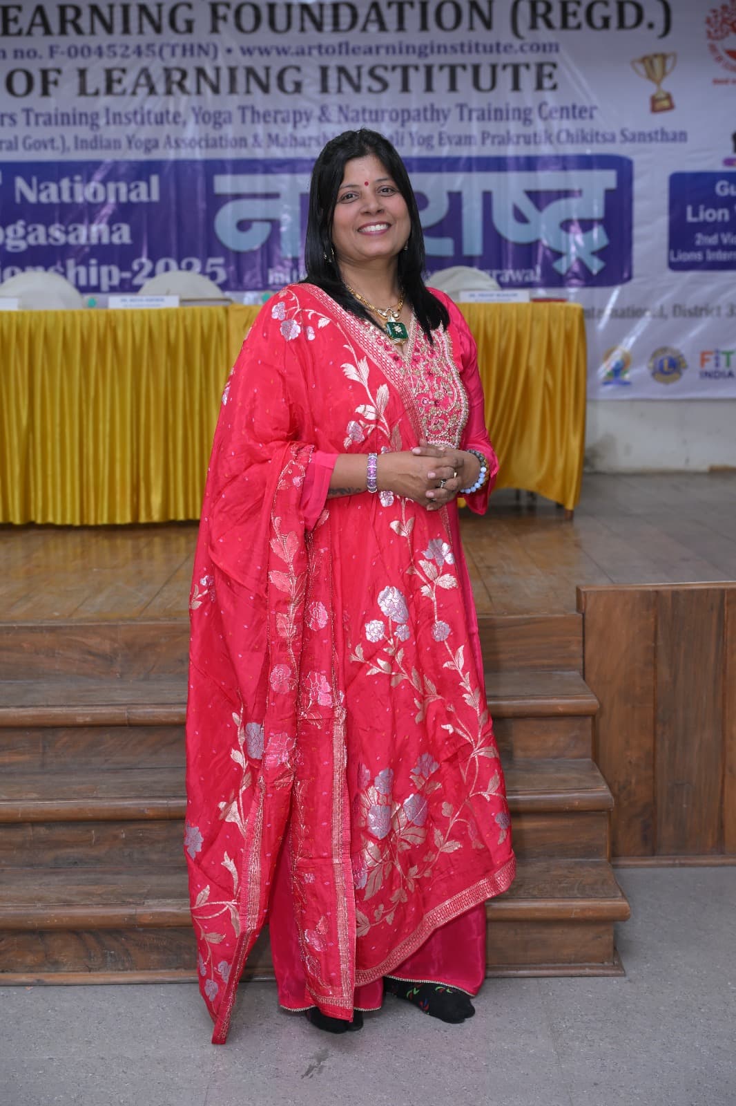 Dr. Reena Agrawal, Yoga Guru, speaking on stage at the Art of Learning Institute's National Yogasana Championship